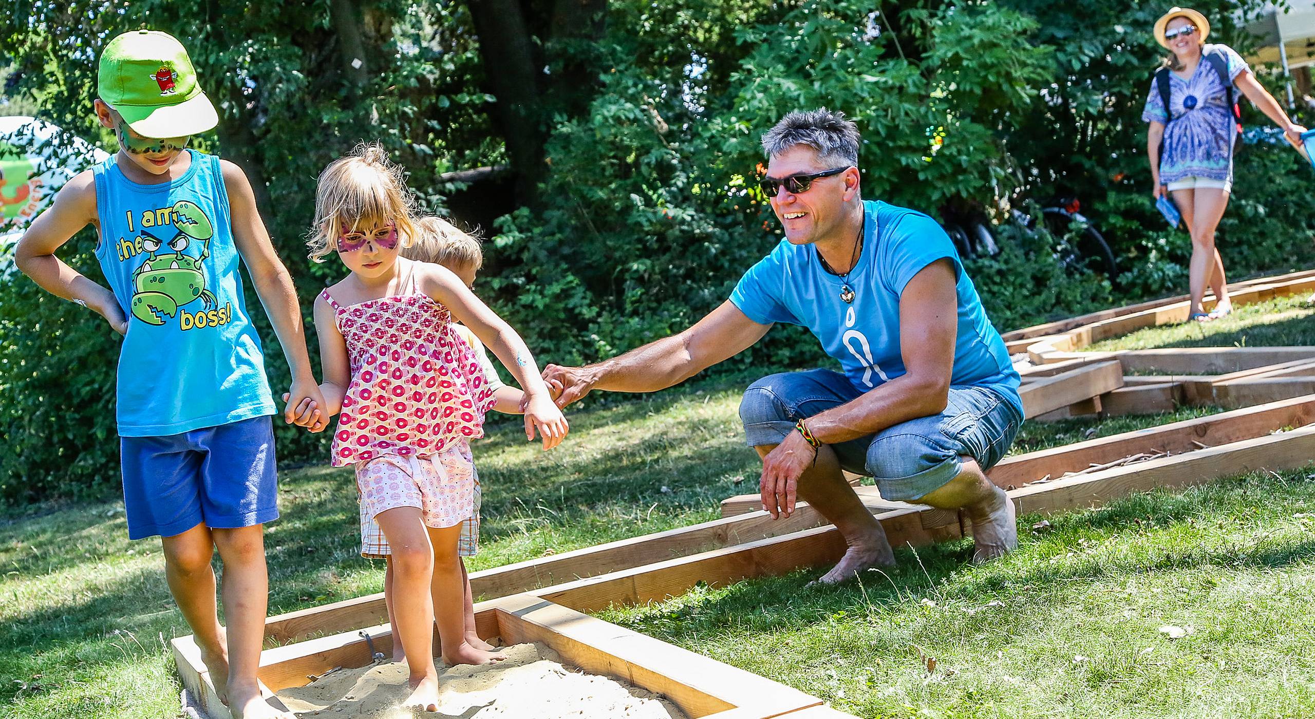 Kinder gehen Hand in Hand den Barfußparcours.