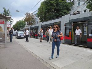 Menschen steigen aus der Straßenbahn aus. Sie betreten die Fahrbahn vor der Straßenbahn. Foto von Maria Grundner