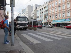 Eine Straßenbahn fährt gerade in eine Haltestelle ein. Es ist eine Inselhaltestelle. Sie befindet sich in Fahrbahnmitte. Foto von Maria Grundner