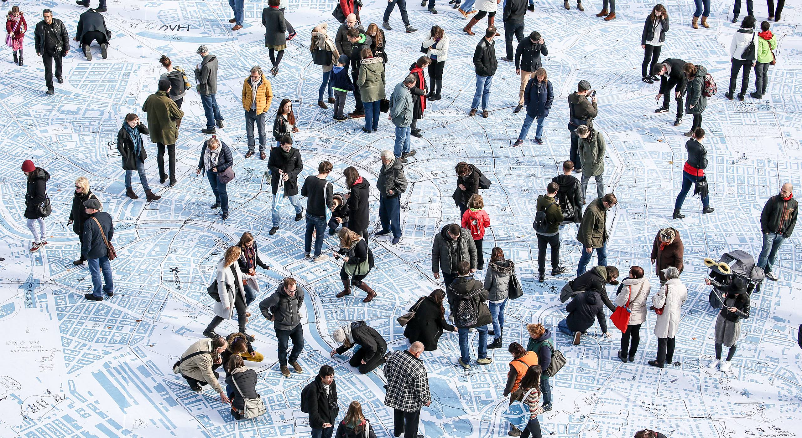 Etwa 50 Personen gehen, stehen und staunen über die größte Wienkarte aller Zeiten am Wiener Rathausplatz.