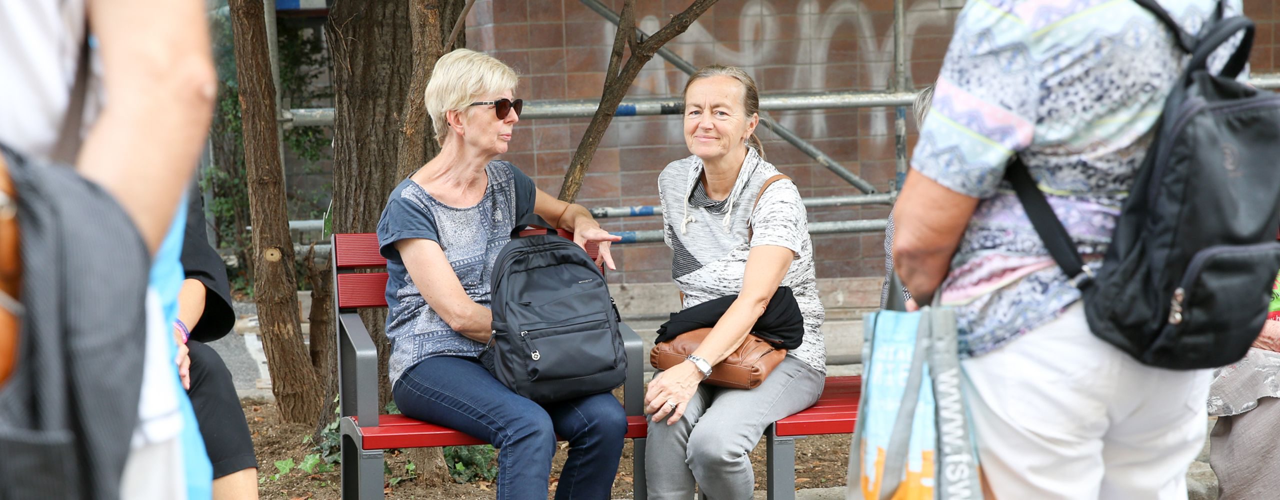 zwei Frauen sitzen auf einer roten Sitzbank. Foto: Mobilitätsagentur Wien/Christian Fürthner