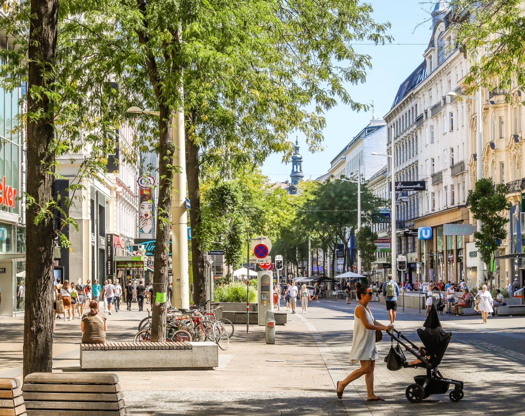 Frau schiebt Kinderwagen über die Fußgängerzone Mariahilfer Straße