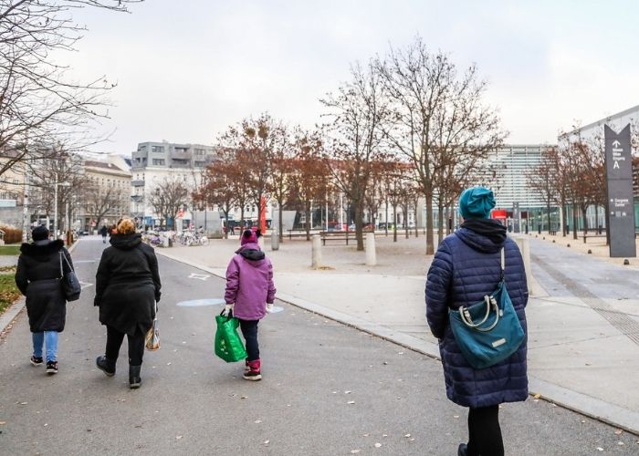 Fußgängerinnen und Fußgänger auf dem Gehweg vom Prater zu Messe Wien.