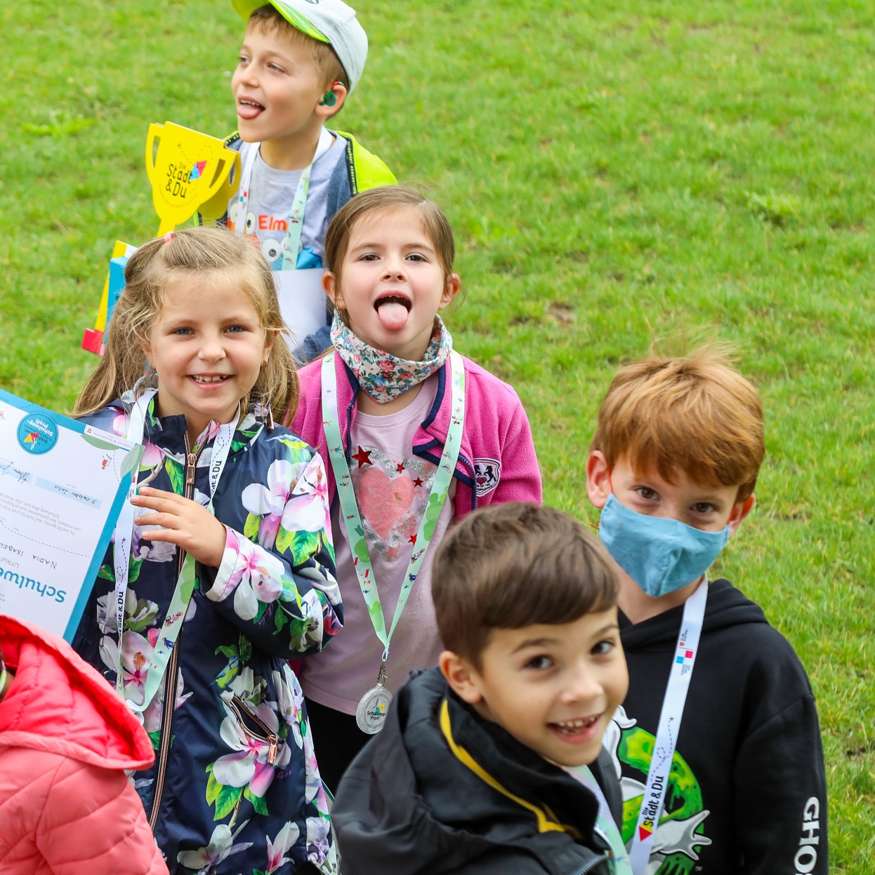 fünf grinsende Kinder bei der Pokalübergabe von "Die Stadt & Du"