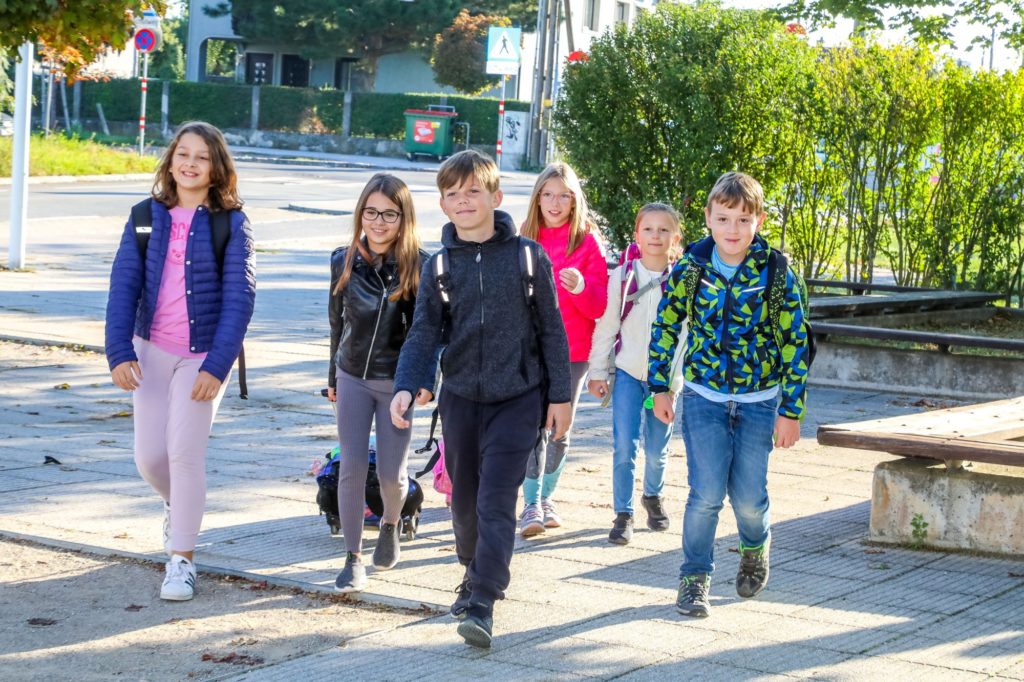 eine Gruppe an Volksschulkinder am Weg zur Schule