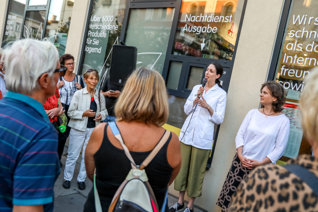 Vor der St. Anna Apotheke in Penzing lauschten die Besucher:innen einer Mitarbeiterin