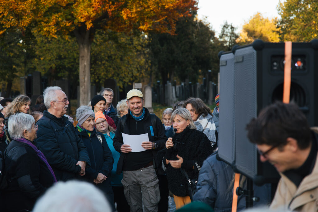 Schorsch Brockmeyer und Sabine Hofer-Gruber heißen die Teilnehmenden beim Geh-Café am Zentralfriedhof willkommen.