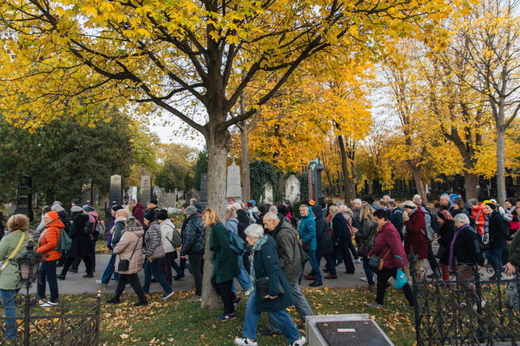 Menschen spazieren bei schönem Herbstwetter durch den Zentralfriedhof